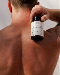 Thumbnail for Person holding a bottle labeled 'Strength & Energy' against a plain background