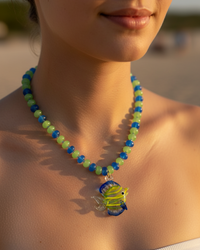 Thumbnail for Close-up of a person wearing a colorful beaded necklace with a fish pendant on a blurred background