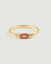 Thumbnail for Gold ring with a red gemstone on a light gray background