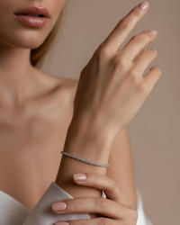 Thumbnail for Close-up of a hand wearing a silver tennis bracelet on a neutral background
