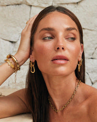 Thumbnail for Tilly Smith wearing gold jewellery against a stone wall