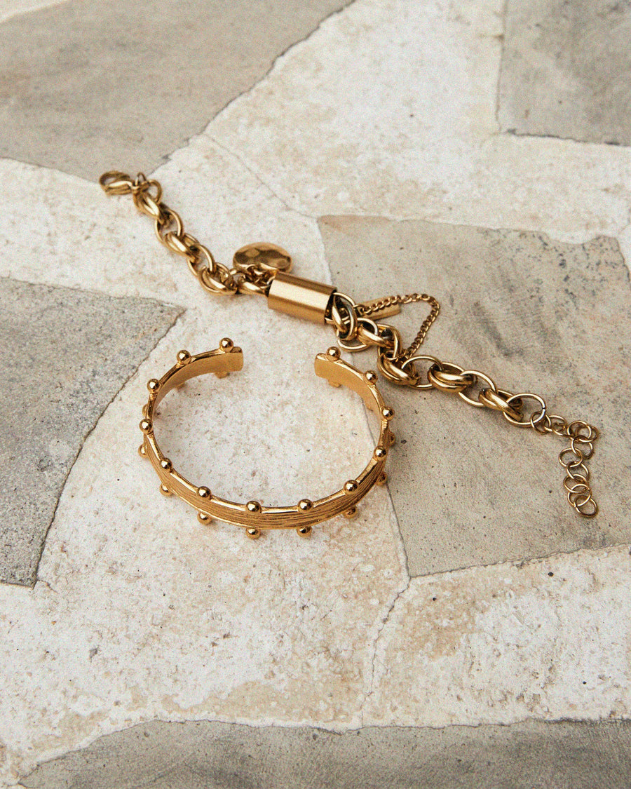 Gold bracelet on a stone surface
