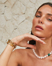 Thumbnail for Tilly Smith wearing a pearl necklace against a stone wall background