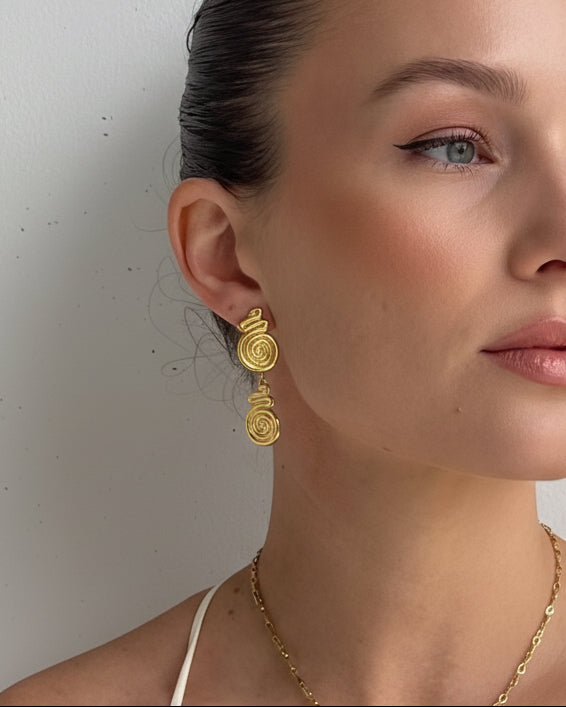 Golden spiral drop stud earrings by Tegan Rae Jewelry, featuring sleek, elegant gold design with a modern spiral shape.