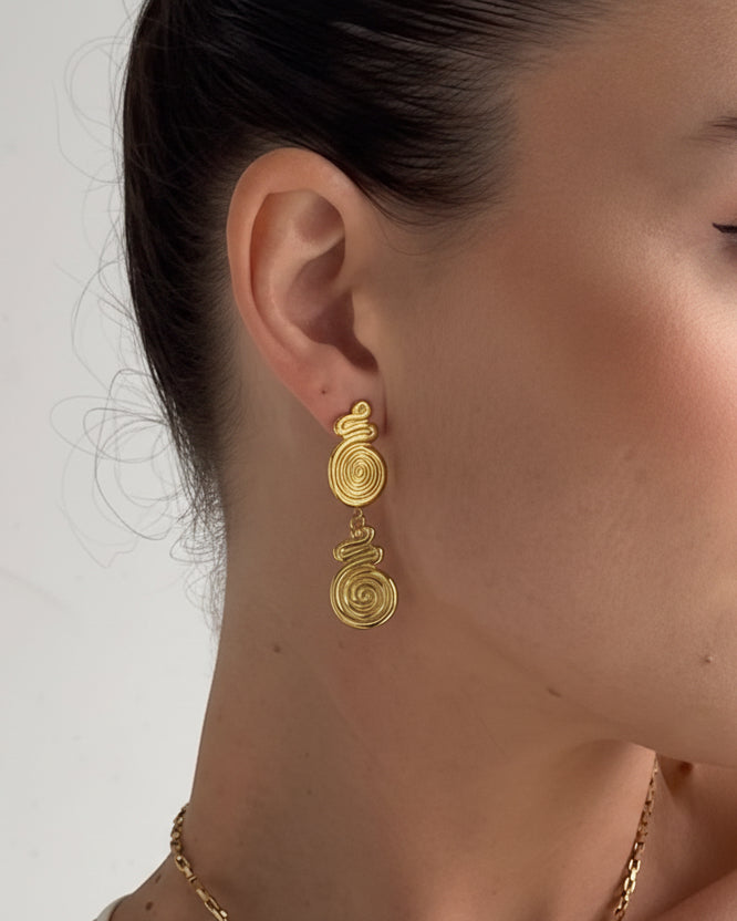 Gold spiral drop stud earrings by Tegan Rae Jewellery featuring elegant, shiny gold design with a spiral motif.