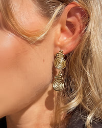 Thumbnail for Gold spiral drop stud earrings by Tegan Rae Jewellery featuring a sleek, elegant design with a shiny golden finish.