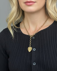 Thumbnail for Gold necklace with a heart pendant on a black ribbed sweater.