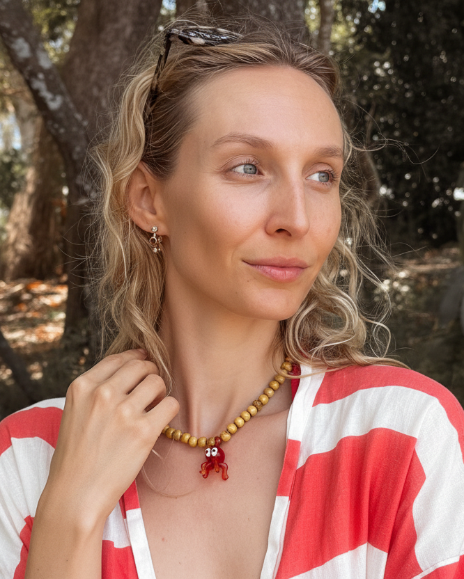 Jodie in a red and white patterned shirt standing in a forest