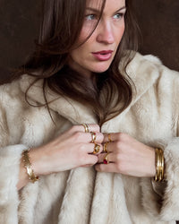 Thumbnail for nikki wearing multiple gold rings and bracelets on a neutral background