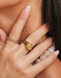 Thumbnail for Close-up of Tilly Smith wearing gold Angel ring and square ring with a neutral background