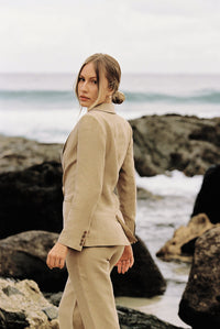 Thumbnail for Woman wearing a taupe blazer and trouser posing on the beach