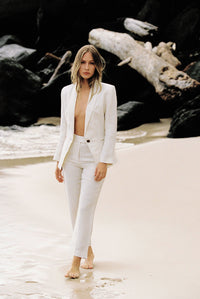 Thumbnail for Model wearing white linen suit posing by the beach
