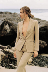 Thumbnail for Model wearing a taupe blazer and trouser posing on the beach