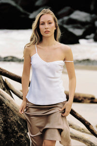 Thumbnail for Woman wearing white silk camisole and taupe silk slip skirt by the beach