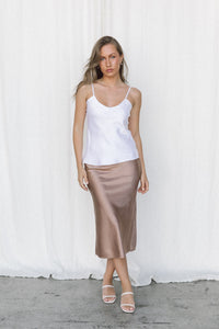 Thumbnail for Model wearing white silk camisole and taupe slip skirt posing in a studio