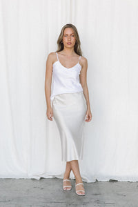 Thumbnail for Model wearing white silk camisole and cream silk skirt posing in a studio