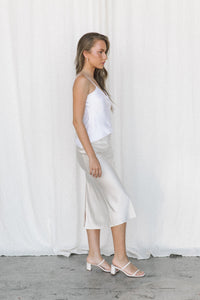 Thumbnail for Model wearing white silk camisole and cream silk slip skirt posing in a studio