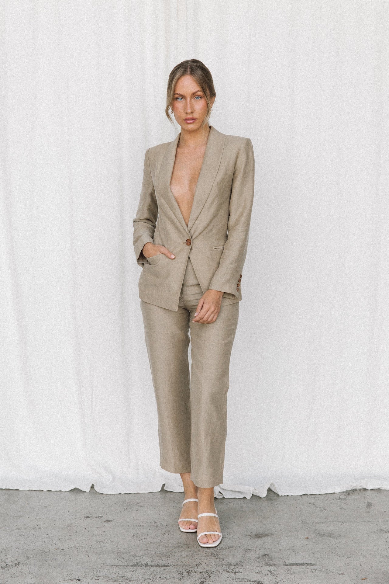 Model wearing a taupe blazer and trouser in a studio